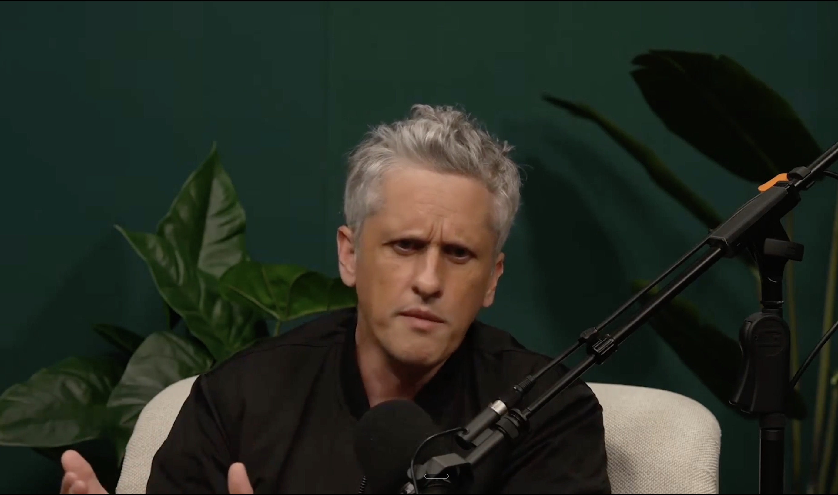 Speaker at a microphone during a video interview about AI and business workflows